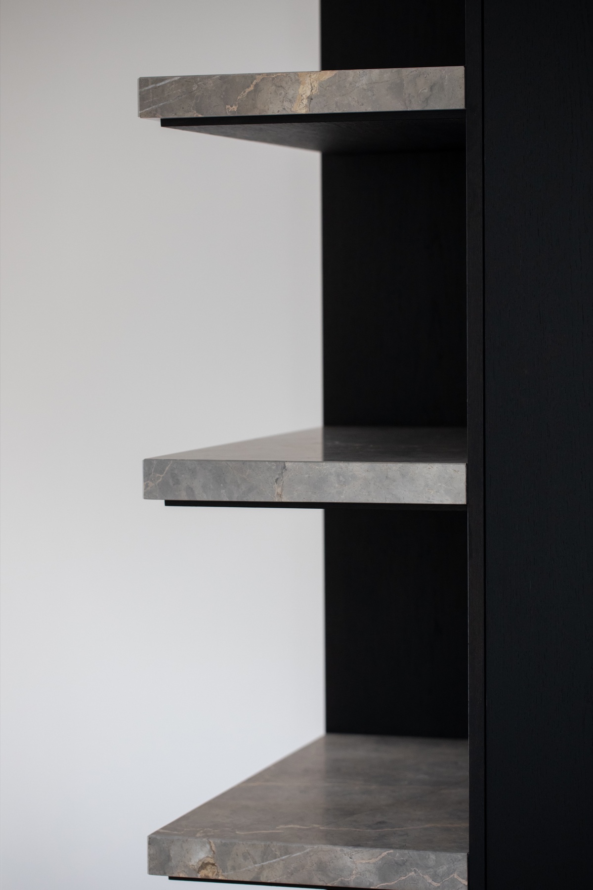 Detail van natuursteen en donker houten maatwerk in House D