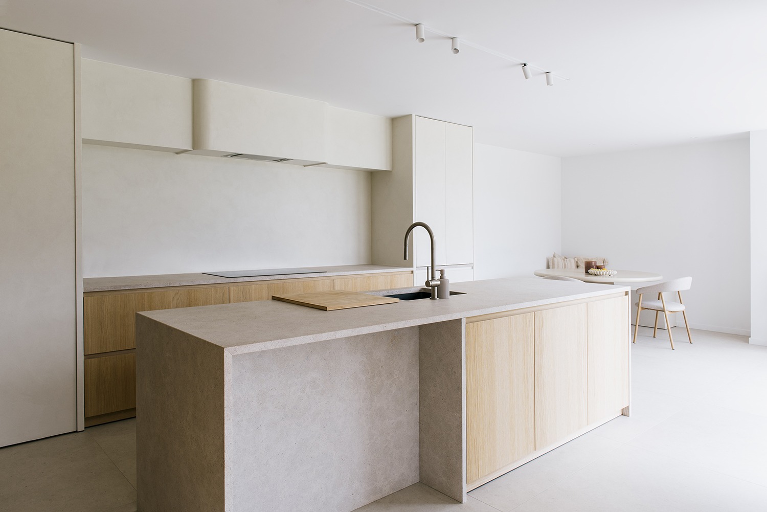 Keuken van House DP met natuurstenen eiland, houten maatwerk en lichte wanden