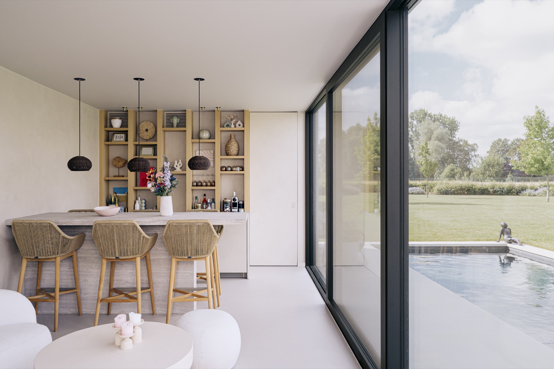 Gerealiseerde bar van Poolhouse V met natuursteen, houten maatwerknissen en uitzicht op het zwembad